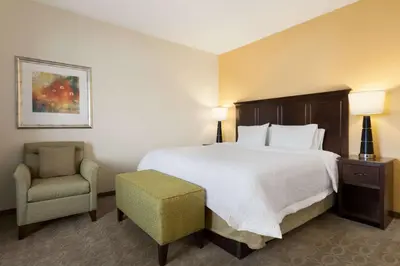 a hotel room with a bed and a chair at Hampton Inn & Suites San Bernardino in San Bernardino