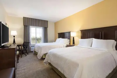 a hotel room with two beds and a television at Hampton Inn & Suites San Bernardino in San Bernardino