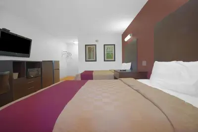 a hotel room with a large bed and a flat screen tv at Mojave Hotel in Mojave
