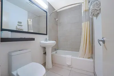 a bathroom with a toilet and a sink and a tub at Mojave Hotel in Mojave