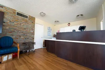 a waiting room with a counter and a blue chair at Mojave Hotel in Mojave