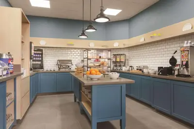 a kitchen with blue cabinets and a counter with bowls of oranges at Country Inn & Suites by Radisson, Bakersfield, CA in Bakersfield