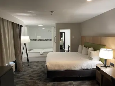 a hotel room with a bed and a bath tub at Country Inn & Suites by Radisson, Bakersfield, CA in Bakersfield