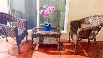 a vase with pink flowers on a table between two chairs at \u534e\u4eba\u533a\u82b1\u56ed\u522b\u5885 in Temple City