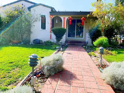 a house with a brick path leading to the front door at \u534e\u4eba\u533a\u82b1\u56ed\u522b\u5885 in Temple City