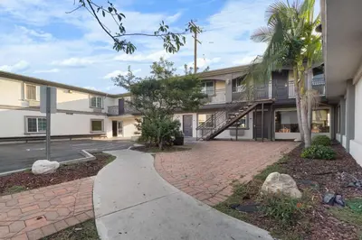 an apartment building with a sidewalk in front of it at Santa Fe Inn Los Angeles in Huntington Park