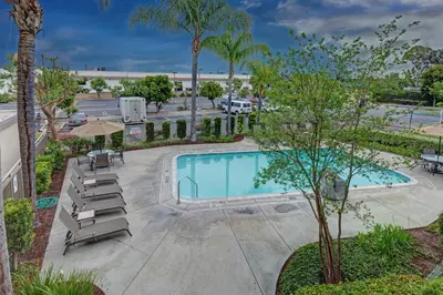 a swimming pool with lounge chairs and a resort at Good Nite Inn Buena Park in Buena Park