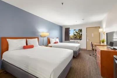 a hotel room with two beds and a desk at Good Nite Inn Camarillo in Camarillo