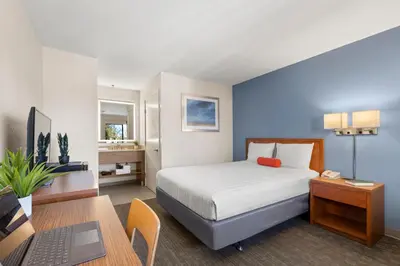a bedroom with a bed and a desk with a laptop at Good Nite Inn Camarillo in Camarillo