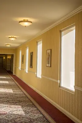 a hallway with yellow walls and a window at Ayres Hotel Manhattan Beach in Hawthorne