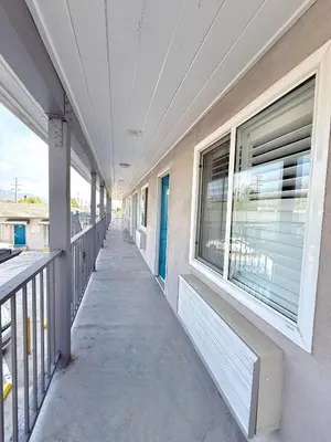 an empty hallway of a building with windows at La Casa Motel, Los Angeles - Burbank Airport in Sun Valley