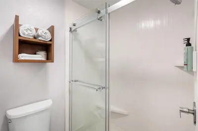 a bathroom with a glass shower with a toilet at Best Western Desert Winds in Mojave