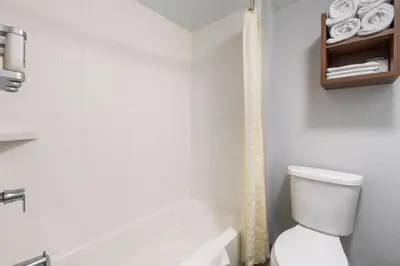 a white bathroom with a toilet and a bath tub at Best Western Desert Winds in Mojave