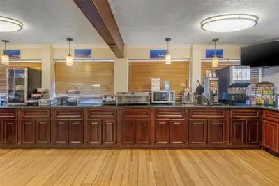 a large kitchen with wooden cabinets and a counter at Best Western Desert Winds in Mojave