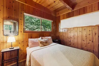a bedroom with a bed in a wooden room at Wooded Comfort in Lake Arrowhead