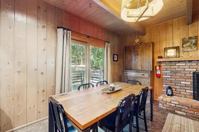 a dining room with a wooden table and chairs at Wooded Comfort in Lake Arrowhead