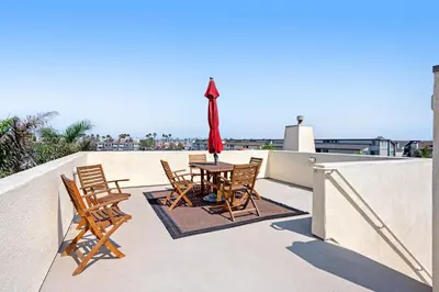 a patio with a table and chairs on a balcony at Seaside Getaway in Oxnard