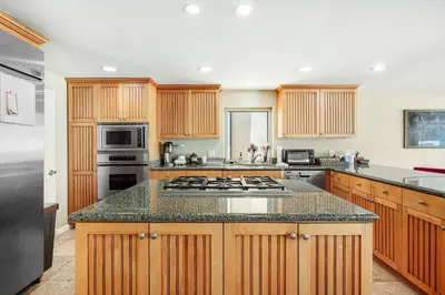 a kitchen with wooden cabinets and a stove top oven at Seaside Getaway in Oxnard