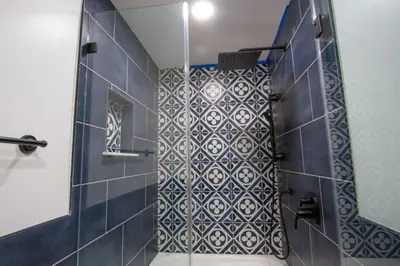 a bathroom with a shower with a blue and white tiles at Dreamy Farmhouse in Studio City in Los Angeles