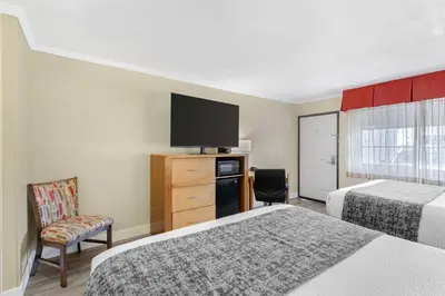 a hotel room with two beds and a flat screen tv at Best Western Plus Ontario Airport & Convention Center in Ontario