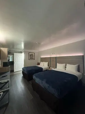 a hotel room with two beds and a television at Rodeway Inn Ventura Midtown in Ventura