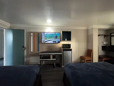 a hotel room with two beds and a desk at Rodeway Inn Ventura Midtown in Ventura