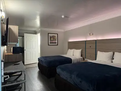 a hotel room with two beds and a television at Rodeway Inn Ventura Midtown in Ventura