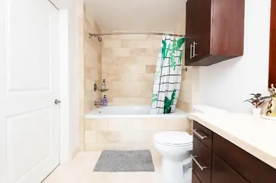 a bathroom with a tub and a toilet and a sink at Sky-Rise Apartments in Los Angeles