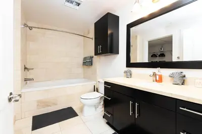 a bathroom with a tub and a toilet and a sink at Sky-Rise Apartments in Los Angeles