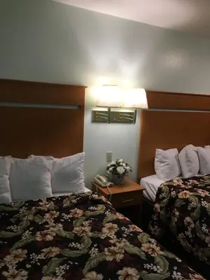 a hotel room with two beds and a phone at OceanView Motel in Huntington Beach