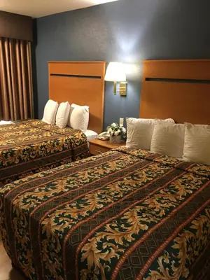 two beds sitting next to each other in a hotel room at OceanView Motel in Huntington Beach
