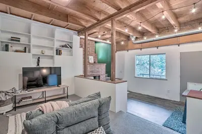 a living room with a couch and a tv at Modern and Unique Cabin with Deck by Lake Gregory! in Crestline