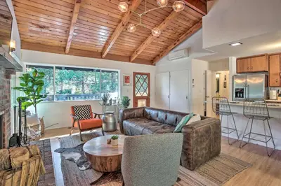 a living room with a couch and a table at Modern and Unique Cabin with Deck by Lake Gregory! in Crestline