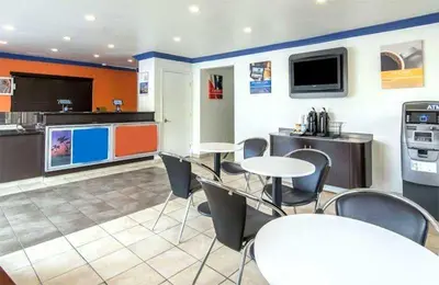 a room with tables and chairs and a kitchen at Beachside Inn in Anaheim