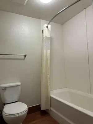 a bathroom with a toilet and a bath tub at Beachside Inn in Anaheim