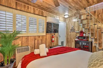 a bedroom with a large bed and wooden walls at 1 Mi to Lake Gregory Boho Crestline Cabin in Crestline