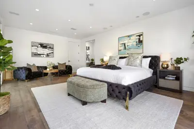 a bedroom with a large bed and a living room at Franklin Modern in Los Angeles
