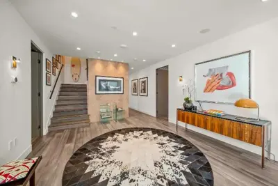 a living room with a staircase and a large rug at Willow Glen in Los Angeles