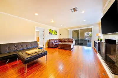 a living room with a leather couch and a television at Disney Getaway in Anaheim