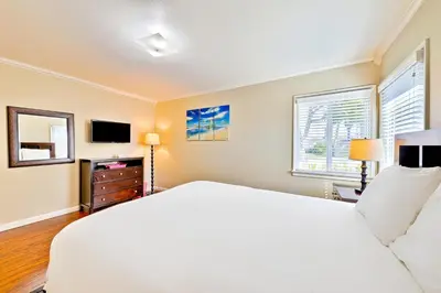 a bedroom with a white bed and a television at Disney Getaway in Anaheim