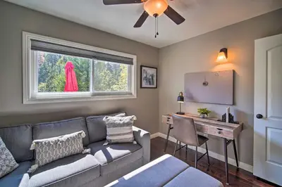 a living room with a couch and a table and a window at Tree-Lined Twin Peaks Cottage with Custom Stream in Twin Peaks