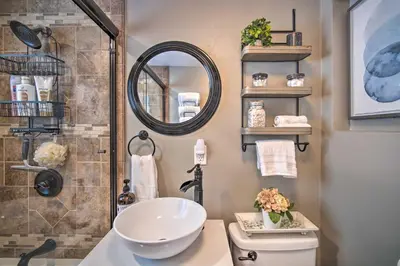 a bathroom with a sink and a toilet and a mirror at Tree-Lined Twin Peaks Cottage with Custom Stream in Twin Peaks