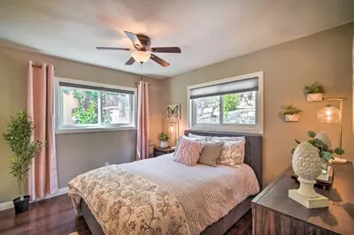 a bedroom with a bed with a ceiling fan and two windows at Tree-Lined Twin Peaks Cottage with Custom Stream in Twin Peaks