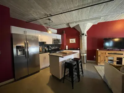 a kitchen with stainless steel appliances and red walls at BO-BOU Suite in Los Angeles