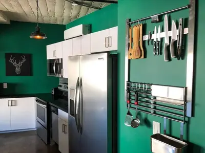 a kitchen with a stainless steel refrigerator and green walls at BO-BOU Suite in Los Angeles