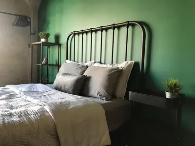 a green bedroom with a bed with white pillows at BO-BOU Suite in Los Angeles