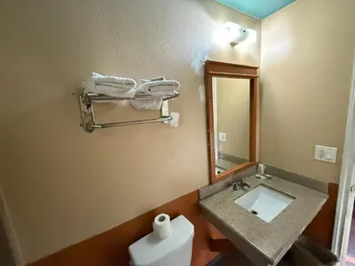 a bathroom with a sink and a mirror and a toilet at Rocky Inn Motel Long Beach, CA in Long Beach