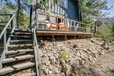 a house on a rocky hill with stairs leading to it at Quiet Sequoia National Forest Cabin with Fireplace in Posey