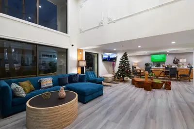 a living room with a blue couch and a christmas tree at Hotel Huntington in Duarte