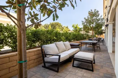 a patio with a couch and a table and a tree at Hotel Huntington in Duarte